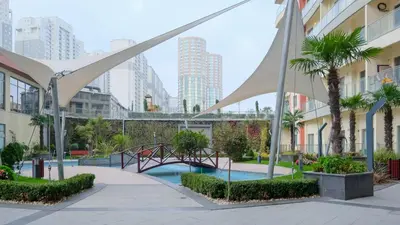 a bridge over a pool in a city with tall buildings at Linkinn Luxury Residence & Spa in Esenyurt