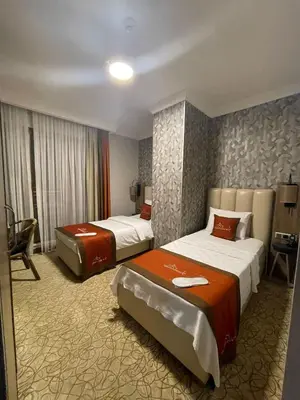 a hotel room with two beds and a desk at Marrakeschotel in Tuzla