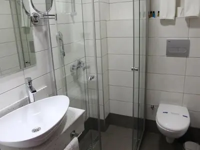 a bathroom with a shower and a sink and a toilet at Marrakeschotel in Tuzla