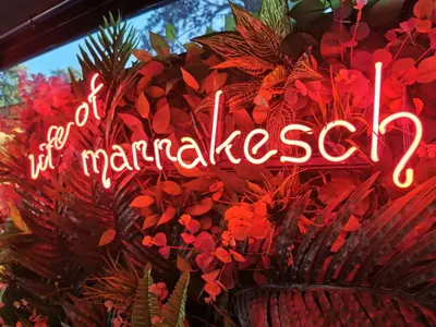 a neon sign that says marmalventory in a window at Marrakeschotel in Tuzla