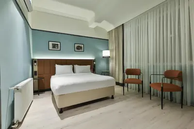 a hotel room with a bed and two chairs at EA Exclusive Hotel in Istanbul
