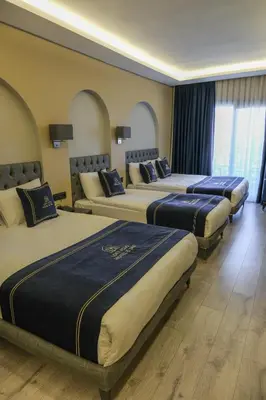 a group of four beds in a hotel room at Plus Hotel & Private Transportation İstanbul Airport-By Loft in Arnavutköy