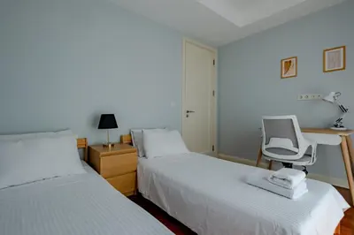 two beds in a room with a desk and a chair at Elysium Soul Residence in Istanbul