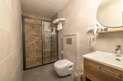 a bathroom with a toilet and a sink and a mirror at BRANDROOM HOTEL in Istanbul