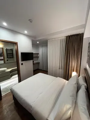 a bedroom with a large white bed and a television at PALMERA HAGIA SOPHIA Hotel in Istanbul