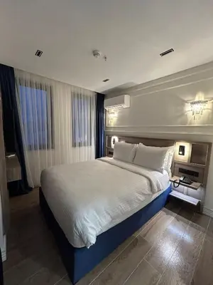 a bedroom with a large bed with white sheets and pillows at Prime Bosphorus Hotel in Istanbul
