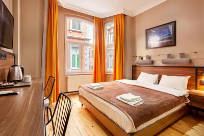 a bedroom with a large bed with orange curtains at Aram Kerasi Rooms in Istanbul