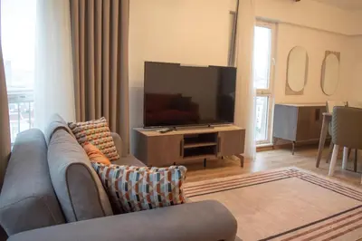a living room with a couch and a flat screen tv at Two Bedroom King Suite IH19 in Esenyurt