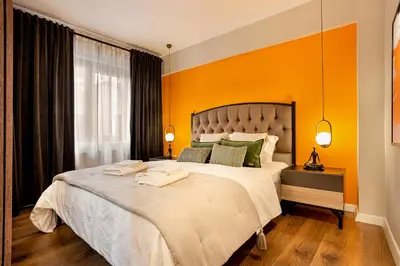 a bedroom with a large bed with an orange wall at Port Galata Suites in Istanbul