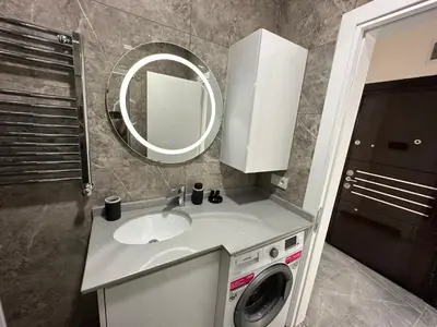 a bathroom with a sink and a washing machine at Rose Plus Residence in Istanbul