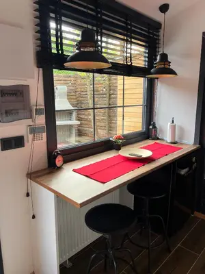 a kitchen with a table and two stools and a window at Pentalow Cabin in Kocaeli