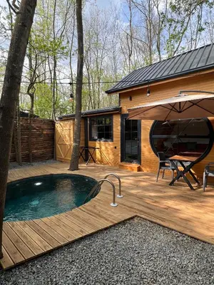 a hot tub on a deck next to a house at Pentalow Cabin in Kocaeli