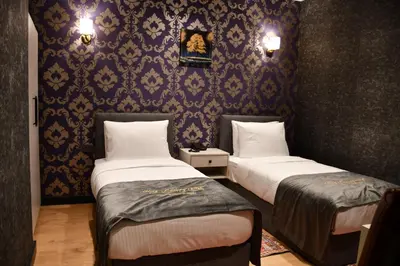two beds in a room with purple wallpaper at Hmz LUXURY HOTEL in Çekmeköy
