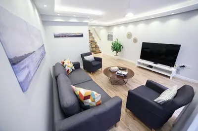 a living room with two couches and a flat screen tv at Modern Super Chic Duplex with a Terrace at the heart of city! in Istanbul