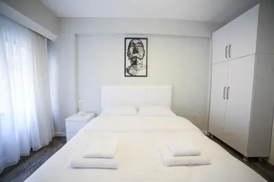 a white bedroom with a large white bed with two pillows at Modern Super Chic Duplex with a Terrace at the heart of city! in Istanbul