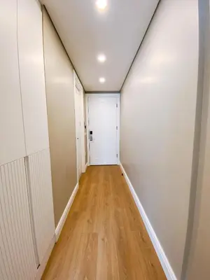 a hallway with a white door and a wooden floor at Bolahenk Suites in Istanbul