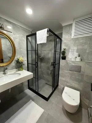 a bathroom with a shower and a toilet and a sink at H&L Suites in Istanbul