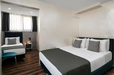 a hotel room with two beds and a chair at İstanbul Efes Hotel in Istanbul