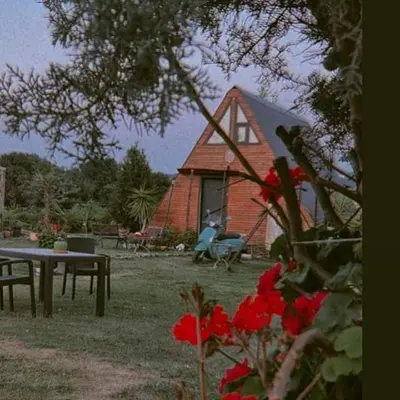 a house with a table and flowers in front of it at Yalova Kasaba Bungalov in Çınarcık