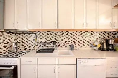 a kitchen with white cabinets and a stove and a sink at Villa Base Kırkpınar Detached Villa with pool in Sapanca