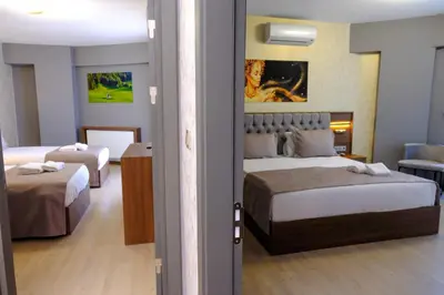 a hotel room with two beds and a couch at Velmore Hotel & Spa in Kestel