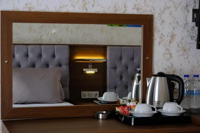 a mirror reflecting a bed in a hotel room at Velmore Hotel & Spa in Kestel