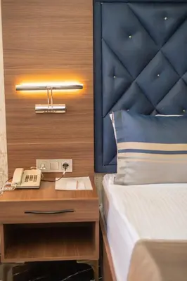 a bedroom with a bed and a phone on a night stand at Velmore Hotel & Spa in Kestel