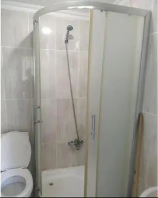 a bathroom with a shower with a toilet and a glass door at Ceylan Köşk Apartman in Istanbul