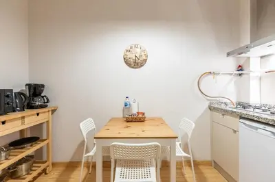 a table and chairs in a kitchen with a clock on the wall at Warm Cozy Charming 2BD2Bath GalataTower Gem! #256 in Istanbul