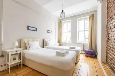a bedroom with two beds and a brick wall at Bright Charming 2BD15Bath GalataTower Home! #257 in Istanbul
