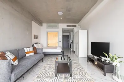 a living room with a couch and a tv at Trendy Cool Bright Studio Parking PoolViews! #254 in Istanbul