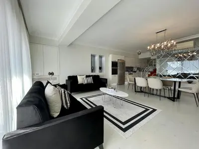 a living room with a black couch and a table at Kaplan Luxury Family Flat - 3 Bedrooms with air conditioning & heating in the City in Istanbul