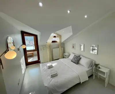 a white bedroom with a bed and a mirror at Kaplan Luxury Family Flat - 3 Bedrooms with air conditioning & heating in the City in Istanbul