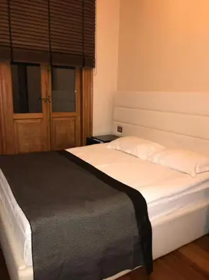 a bedroom with a white bed with a black blanket at Aslan Residence in Istanbul