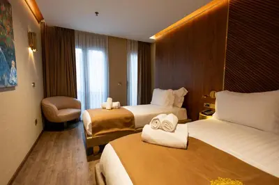 a hotel room with two beds and a chair at Kate Hotel Special Class & SPA in Istanbul