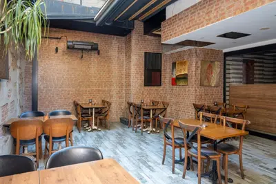 a restaurant with wooden tables and chairs and a brick wall at Hotel Blisstanbul in Istanbul