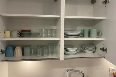 a kitchen cabinet filled with plates and mugs and dishes at Cebeci Chic and Cosy Apartments in Istanbul
