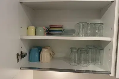 a cabinet filled with glass jars and plates at Cebeci Chic and Cosy Apartments in Istanbul
