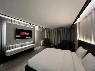 a hotel room with a bed and a tv on the wall at BALA HOTEL in Tuzla