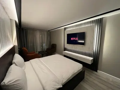 a bedroom with a bed and a tv on the wall at BALA HOTEL in Tuzla