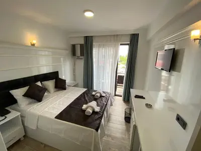 a bedroom with a bed with a teddy bear on it at ATAŞ AQUA OTEL AVŞA in Samanlı