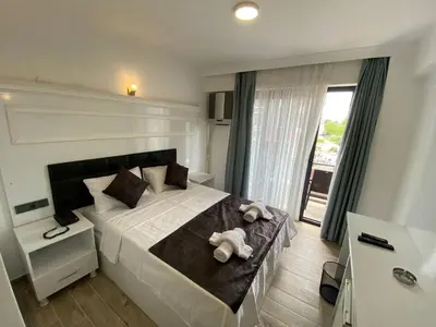 a bedroom with a large bed with towels on it at ATAŞ AQUA OTEL AVŞA in Samanlı