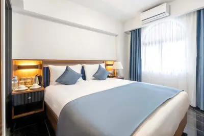 a bedroom with a large white bed with blue pillows at THE BOSFOR HOTEL in Istanbul