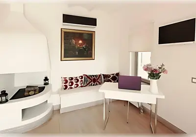 a white living room with a laptop on a table at Baylo Suites in Istanbul