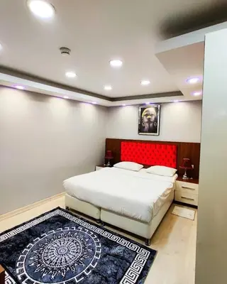 a bedroom with a large bed with a red headboard at EYFEL HOTEL in Istanbul