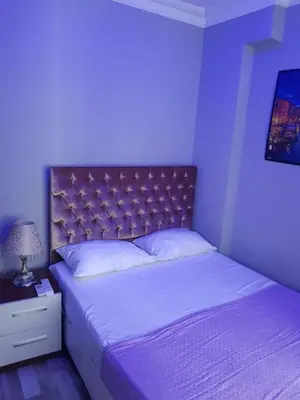 a bedroom with a large bed with a purple light at EYFEL HOTEL in Istanbul