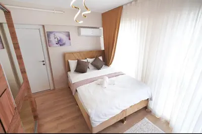 a bedroom with a bed with white sheets and a window at Two Bedroom King Deluxe Suite IS9 in Esenyurt