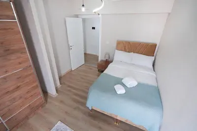 a small bedroom with a bed with two towels on it at Two Bedroom King Deluxe Suite IS9 in Esenyurt