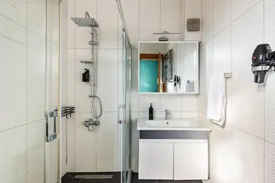 a white bathroom with a sink and a shower at Waterfront Apartment by the Tram- Terrace with Dome & Golden Horn View in Fatih in Istanbul