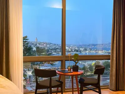 a room with a table and chairs and a large window at The Haliç Bosphorus Hotel in Istanbul